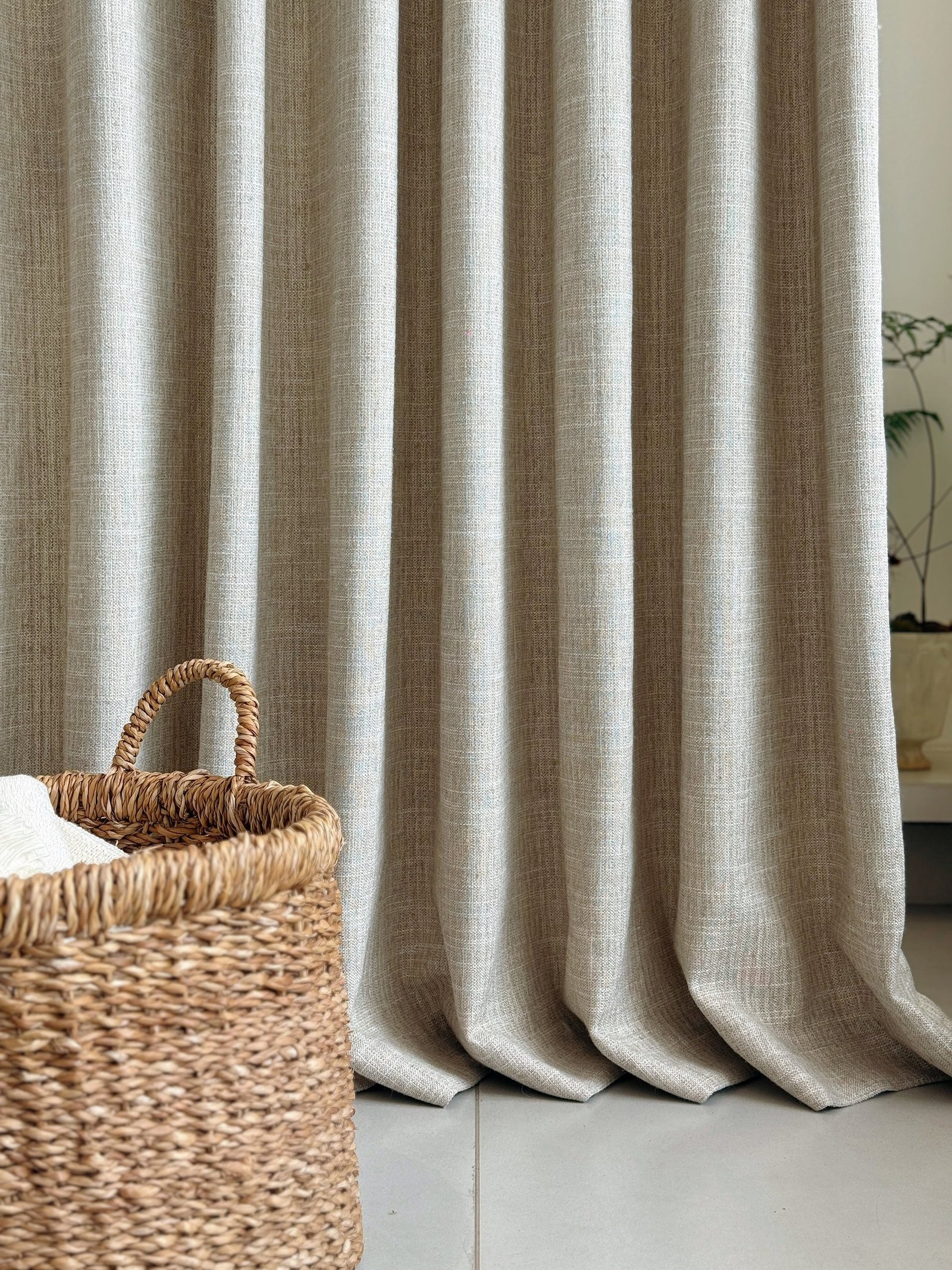 Warm neutral curtain fabric folds by a window