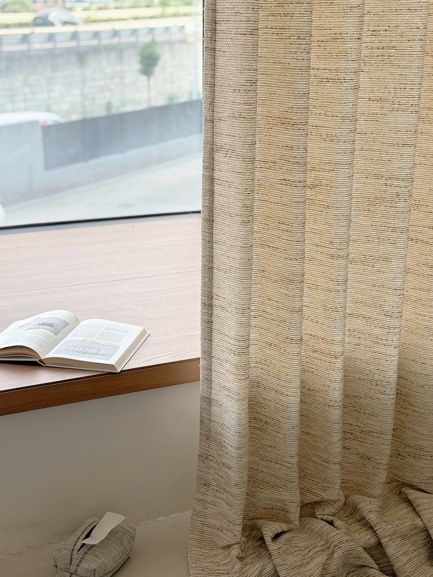 Sheer curtain panel filtering daylight beside a window